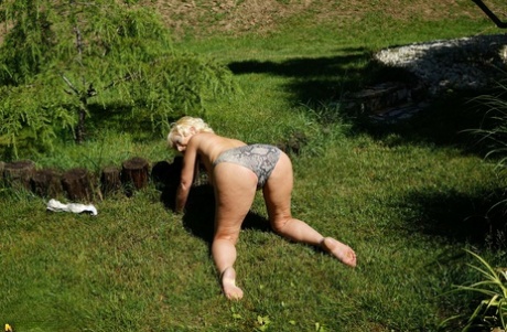 Mature blonde woman takes off her bikini while wandering around her property 76110865